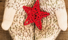 Hands wearing mittens, holding red star in the middle