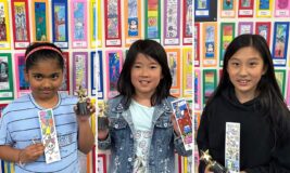 Winners of the 2023 Kids Bookmark Contest holding up their winning entries and trophies