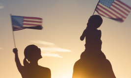 Silhouette of family waving American flags