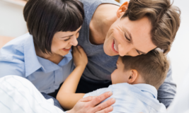 Mother and father hugging their child